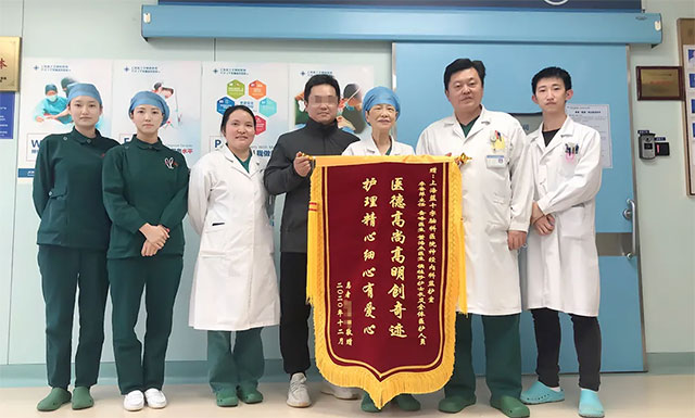 患者家屬贈送錦旗并與李主任團(tuán)隊合影